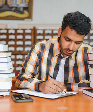 male-indian-student-library-with-book (1) male-indian-student-library-with-book (1)