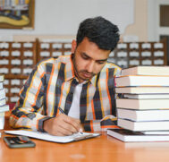 male-indian-student-library-with-book