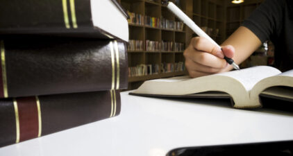 Woman reading book in library. Join us in our fully tech-equipped classrooms, designed for learning and productivity.